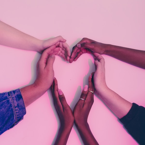 multi-racial hands coming together in a heart shape